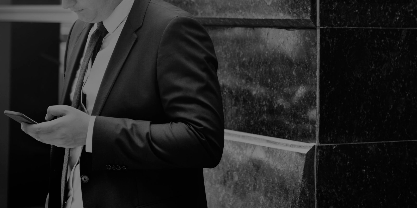 Closeup of businessman using mobile phone gray scale